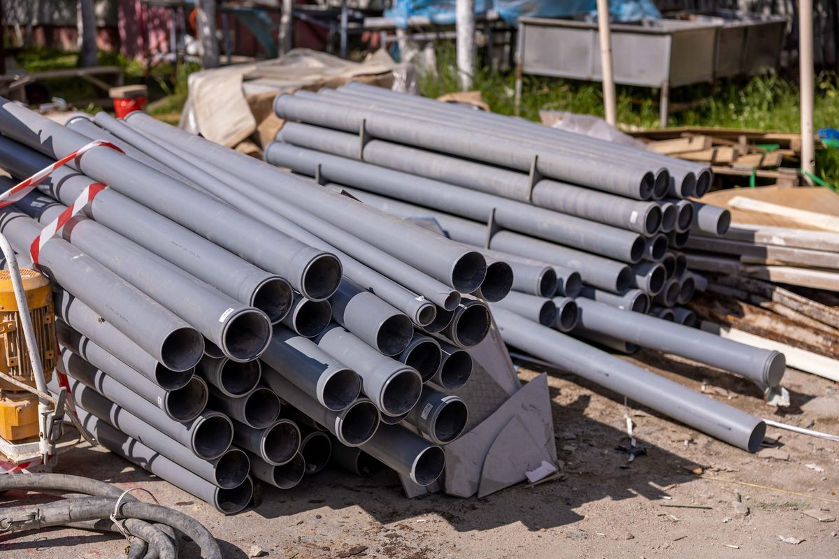 Stack of gray PVC pipes at a construction site